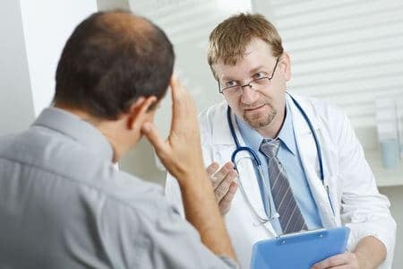 Paciente con encabezado hablando con un médico.